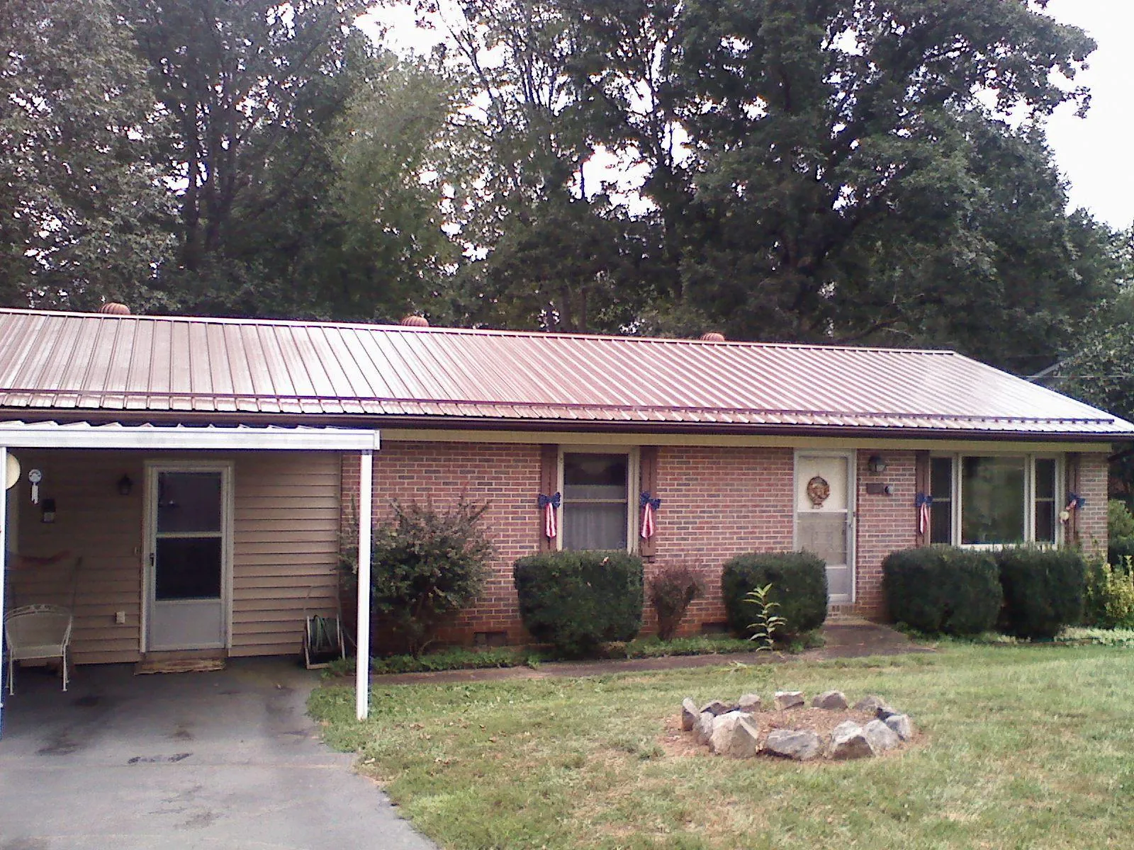 Bronze metal roof and carport on a brick ranch home — Roof Repair work by our crew in Wyoming